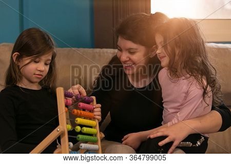 Mother Helping Her Children Learn Math Using An Abacus