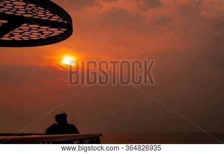Backpacker Watching Sunset Over The Sea At Laem Thaen Viewpoint, Chonburi, Thailand. Beautiful Orang