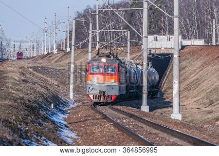 Freight Train Moves Through The Tunnel At Spring Day Time.