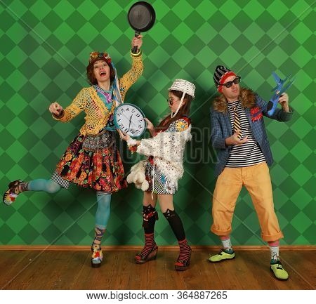 Turretless Freak Family Dressed In Color Unthinkable Clothes Pose In The Studio On A Green Backgroun