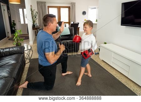 Covid-19 Shutdown. Father And Son Having Fun Boxing Together And Staying Physically Active At Home D