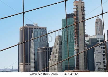 New York City Tall Buildings Architecture Shot Through Net Of Brooklyn Bridge