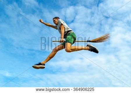 Young Man Flying On The Broom With Outstretched Arm In The Blue Sky Of Siquijor