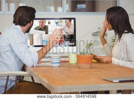 Couple waving during a video call with their friends and family on computer self isolating at home with coronavirus Covid 19 spreading. Public health social distancing and self isolation in quarantine