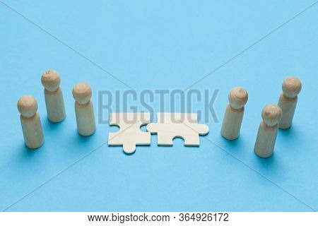 Wooden Figures With Pazzles On Blue Background. Agreement Between Business Mans, Cooperation And Dea