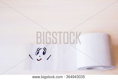 Toilet Paper With Funny Smiling Face On Wooden Background, Copyspace. Supplies For Quarantine Isolat