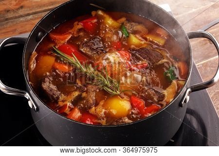 Meat Stew With Vegetables. Beef Stew With Potatoes, Carrots And Fresh Herbs On Table.