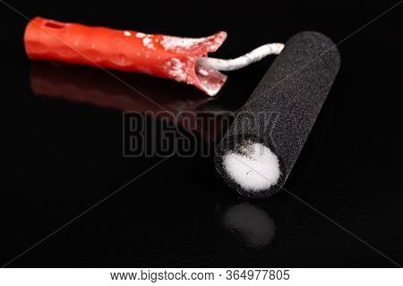 Paint Roller And Black Paint. Painting With Black Paint On A Flat Surface.