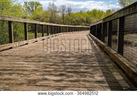 Low Angle View Of A Pedestrain Footbridge In Elm Creek Park Reserve Along The Trails On A Spring Day