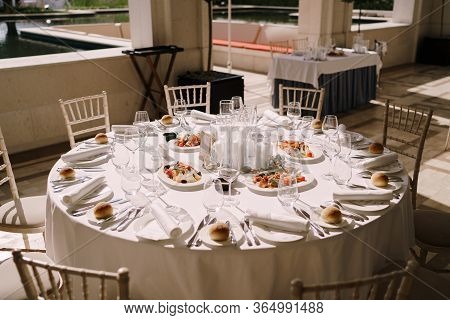 Wedding Dinner Table Reception. Round Banquet Table With White Tablecloth And Cream Chiseds Chiavari