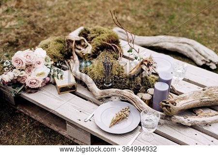 Wedding Dinner Table Reception. An Impromptu Table For Two Of The Construction Pallet On Grey Grass 