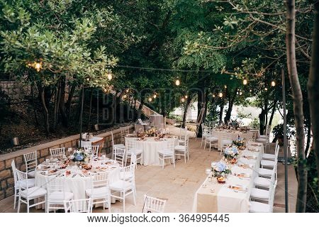 Wedding Dinner Table Reception. Round Tables With White Tablecloths, Brown Runners, Bouquets Flowers