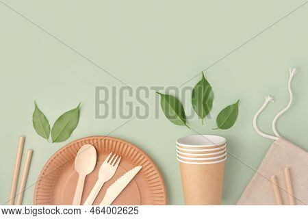 Eco - Friendly Tableware On Green Background. Top View. Plastic Free Set Of Brown Paper Utensil. Str