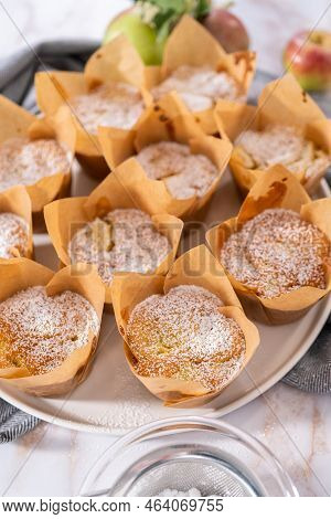 Garnishing Freshly Baked Apple Sharlotka Muffin Dusted With Powdered Sugar.