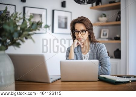 Thinking Woman Sitting At Laptops And Hands On Face. Careworn Business Woman Working From Home. Home