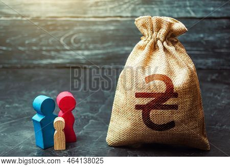 Family Figurines And Ukrainian Hryvnia Money Bag. Social Assistance And Support. High Debt. Social R