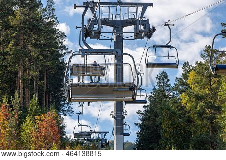 Ski Lift In Mountain Autumn Forest. Climbing Uphill On A Cable Car. Open Cable Car Line. Chairlift A