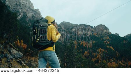 Woman In Yellow Sweater With Hike Backpack Stand On Epic Mountain Landscape At Autumn Trip Adventure