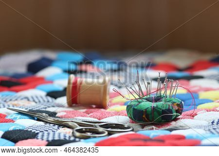 Quilting Supplies On A Colorful Hexagon Mosaic Patterned Quilt