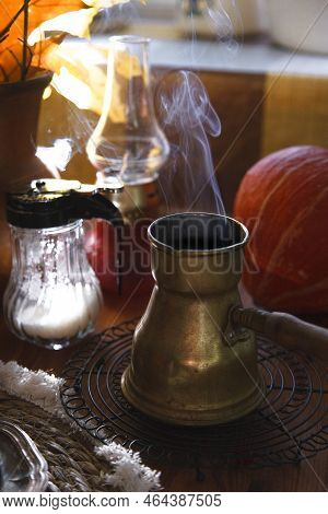 Yellow Metal Vintage Cerve With Steam Over It With Pumpkin And Autumn Leaves On Wooden Table, Cozy A