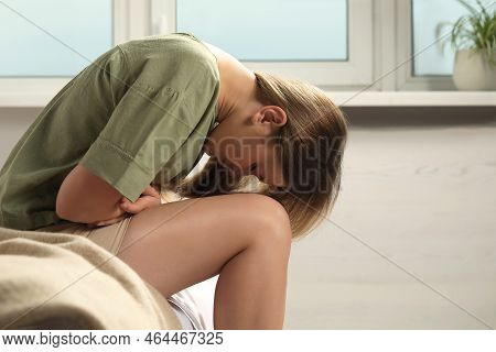 Young Woman Suffering From Menstrual Pain On Bed At Home