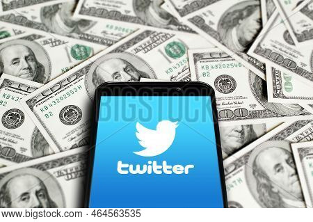 Twitter Logo On Smartphone Screen On Background Of Dollars. Twitter Is A Microblogging And Social Ne