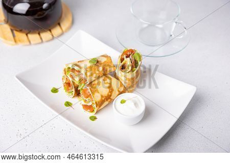 Pancakes With Salmon (trout), Sour Cream, Greenstuff And Tea. Thin, Not Sweet Blinchiki Stuffed With