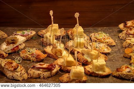 Many Tapas, Small Baguettes Pieces With Toppings On A Board.