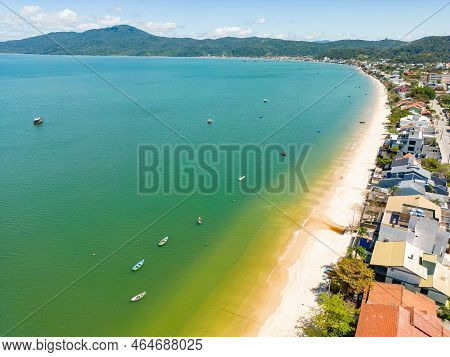 Aerial View Of Beach With Boats, Houses And Forest