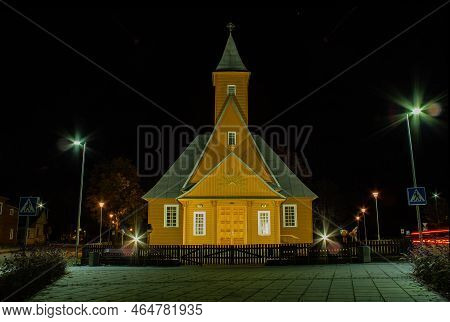 Varena, Lithuania - Nov 2, 2022: Wooden Old Varena St. Archangel Michael Church. Autumn Night.