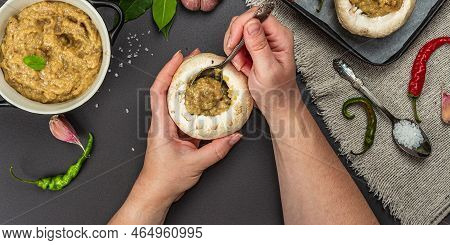 Female Hands Stuff Raw Mushroom Caps. Fresh Champignons Ready For Baking, Spices, Vegetables