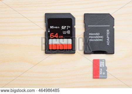 Modern Fast Sd Memory Card, Micro Sd Card And Adapter On Light Wooden Table