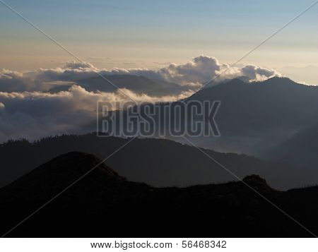Clouds creeping over a mountain ridge