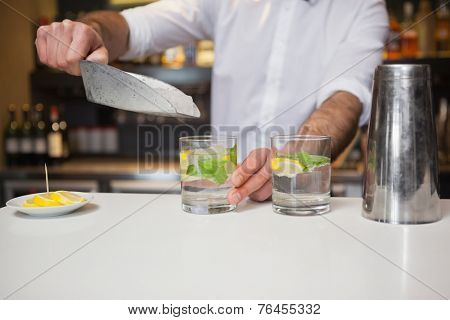 Happy bartender making a cocktail in a bar