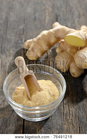 ginger root and ground ginger spice on wooden background