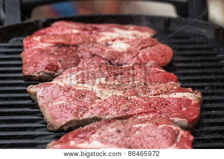 Fresh beef steaks on grill