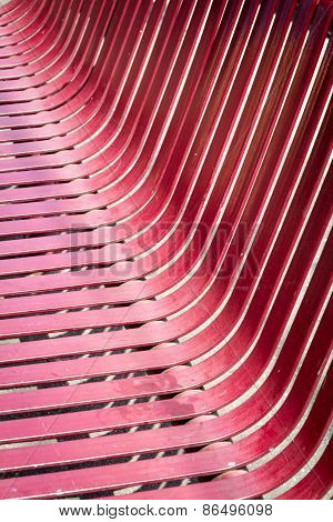 A red metal outdoor chair looking low and on an angle
