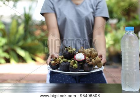 Lifestyle Woman holding plate of fruit in hands and watre