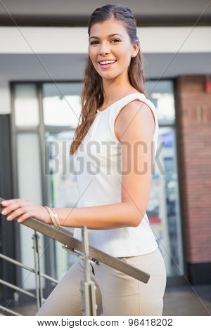 Portrait of smiling woman going upstairs at the shoppingmall