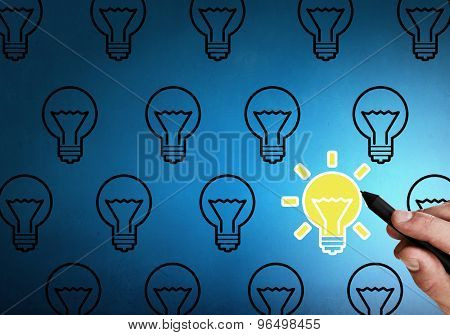 Close up of hand darwing light bulb with marker