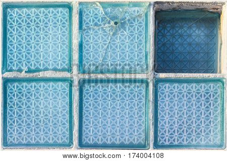 Decorative and glossy glass block window in blue as a texture or for background. Broken place. The wall. Geometric background.