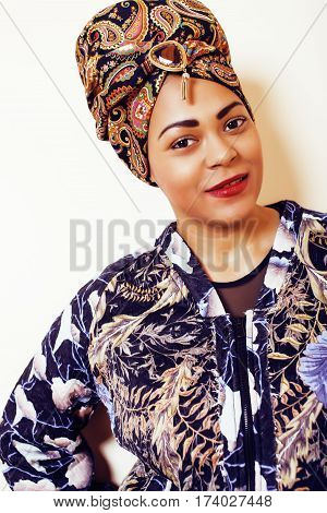 beauty bright african woman with creative make up, shawl on head like cubian closeup smiling, cheerful tan , lifestyle people concept close up