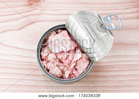 canned tuna on wood table / Canned albacore pink meat tuna packed in water