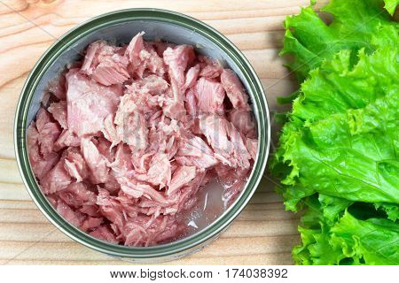 canned tuna on wood table / Canned albacore pink meat tuna packed in water