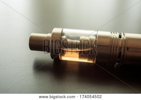 Electronic cigarette with liquid tank on the table. Vaping. Close up. ENDS.