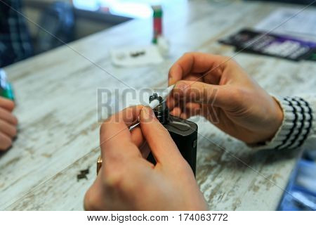 Male Hands Fill Cotton Wool For The E-cigarette. After-sales Service Of The Electronic Cigarette. En