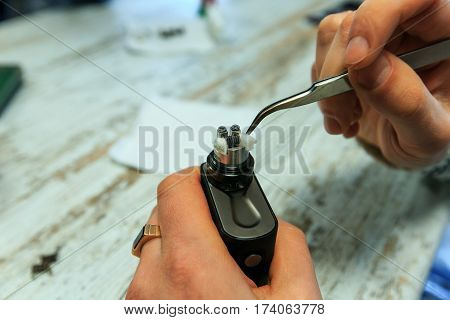 Male Hands Fill Cotton Wool For The E-cigarette. After-sales Service Of The Electronic Cigarette. En