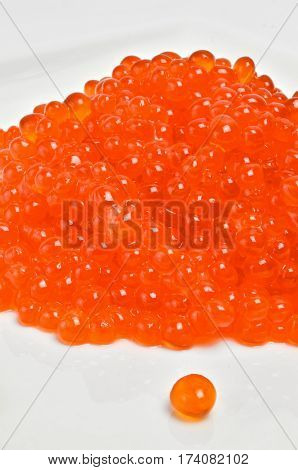 Red salmon caviar heap isolated on white.