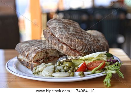 Traditional maltese dish - ftira. Malta food. Typical Maltese bread called ftira accompanied by french fries