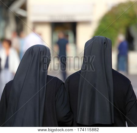 Two Sisters With Long Blacks Clothes They Walk Through The Stree